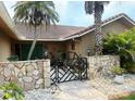 Inviting stone entrance with a decorative gate and well-maintained landscaping at 3764 Torrey Pines Blvd, Sarasota, FL 34238