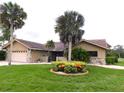 Beautiful single-story home featuring a lush lawn, mature palms, and decorative stone accents at 3764 Torrey Pines Blvd, Sarasota, FL 34238