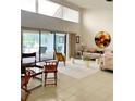 Bright living room with high ceilings, tile floors, and sliding glass doors to outdoor space at 3764 Torrey Pines Blvd, Sarasota, FL 34238