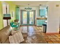 Bright, open kitchen features terracotta tile flooring, turquoise cabinets, and access to the back deck at 3767 Pinstar Ter, North Port, FL 34287