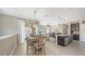Open-concept dining area with tile flooring, stylish light fixture, and sliding glass doors to a balcony at 4267 Expedition Way, Osprey, FL 34229