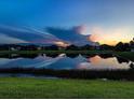 Beautiful pond view reflecting the sunset and nearby homes, creating a serene and picturesque landscape at 4704 Sarca Ct, Lakewood Ranch, FL 34211