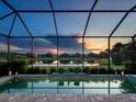 Relaxing screened-in pool offering serene views of the lake and neighborhood homes, perfect for tranquil evenings at 4704 Sarca Ct, Lakewood Ranch, FL 34211
