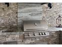 Outdoor kitchen featuring a stainless steel grill, granite countertop, and a sink at 4735 Cassio Ct, Bradenton, FL 34211