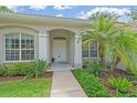 Inviting home entryway with decorative columns, and lush landscaping at 5619 Oak Grove Ct, Sarasota, FL 34233