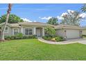 Charming home exterior with a well-manicured lawn and a two car garage at 5619 Oak Grove Ct, Sarasota, FL 34233