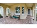 Inviting front porch with brick flooring and comfortable seating area at 5662 Fossano Dr, Sarasota, FL 34238