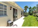 Rear exterior featuring sliding glass doors and manicured lawn; ideal for enjoying the outdoors at 5779 Wilena Pl, Sarasota, FL 34238