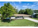 Exterior view of well-maintained single-story home with a large, grassy front lawn and attached two-car garage at 616 59Th Nw St, Bradenton, FL 34209