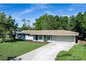 Exterior view of home with well-maintained lawn, large driveway, and attached two-car garage in a residential area at 616 59Th Nw St, Bradenton, FL 34209