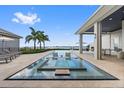 Beautiful backyard featuring a modern pool with lounging area and waterfront views at 676 Regatta Way, Bradenton, FL 34208