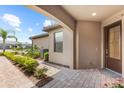 Inviting covered front porch with decorative brickwork and a stylish front door at 7661 Summerland Cv, Bradenton, FL 34202