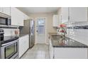 Bright kitchen features white cabinets, stainless steel appliances, granite countertops, and tiled backsplash at 8258 San Jacinto Ave, North Port, FL 34287