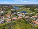 Serene aerial view of a residential community surrounded by lush greenery, ponds, and a golf course at 8445 Lone Eagle Way, Sarasota, FL 34241