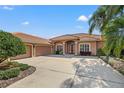 Charming single-story home with a tile roof, arched entryway, and lush landscaping at 8445 Lone Eagle Way, Sarasota, FL 34241