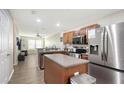 Open-concept kitchen with stainless appliances, center island, that flows into the living area at 8907 White Sage Loop, Lakewood Ranch, FL 34202