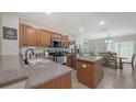 Modern kitchen with stainless steel appliances, island and an adjacent dining area at 8907 White Sage Loop, Lakewood Ranch, FL 34202