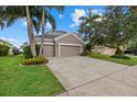 Beautiful home with a large driveway, well-manicured lawn, mature trees, and a two-car garage at 9927 58Th E St, Parrish, FL 34219