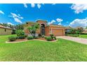 Lovely home with green grass, mature landscaping, and a decorative driveway at 12851 24Th Street E Cir, Parrish, FL 34219