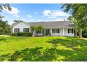 Charming home with a manicured lawn, lush landscaping, and a welcoming front porch at 21705 67Th E Ave, Bradenton, FL 34211