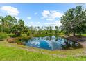 Picturesque pond reflecting the blue sky and surrounding trees, adding natural beauty to the property at 21705 67Th E Ave, Bradenton, FL 34211
