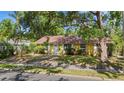 Quaint yellow home with mature trees, a well-kept lawn, and a welcoming entrance at 218 32Nd W St, Bradenton, FL 34205