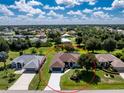 Aerial view of a single-story home and its neighborhood with lush greenery, well-manicured lawns and mature trees at 234 Antofagasta St, Punta Gorda, FL 33983