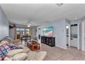 Spacious living room with tile floors, modern TV, and a sliding glass door to a private balcony at 25100 Sandhill Blvd # V202, Punta Gorda, FL 33983