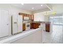 Open-concept kitchen with wood cabinets, granite countertops, and a seamless transition to the dining area at 26548 Castleview Way, Wesley Chapel, FL 33544