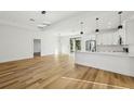 Bright living space with light hardwood floors next to the kitchen with modern recessed lighting at 2813 Sally Ln, North Port, FL 34286