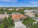 Beautiful aerial view of a beige single Gathering home with a tile roof, landscaped yard, and three car garage at 2937 Seasons Blvd, Sarasota, FL 34240
