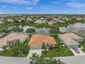 An aerial view of a well-maintained single-Gathering home featuring lush green lawn, mature landscaping, and a beige exterior at 2937 Seasons Blvd, Sarasota, FL 34240