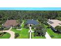 Aerial view of a home with beautifully landscaped yard, trees, and proximity to a dense forest at 2962 Wilderness E Blvd, Parrish, FL 34219