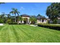 Lush green lawn leads to an elegant home featuring classic architecture and well-maintained landscaping at 2962 Wilderness E Blvd, Parrish, FL 34219
