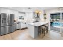 Modern kitchen featuring stainless steel appliances, a stylish island with seating, and easy access to the pool area at 327 Francis Dr, Apollo Beach, FL 33572