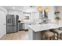 Bright kitchen with stainless steel appliances, a kitchen island with bar stool seating, and sleek white cabinetry at 327 Francis Dr, Apollo Beach, FL 33572