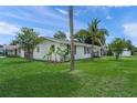 Well-kept white home with lush green lawn and mature landscaping at 3310 W 9Th Ave, Bradenton, FL 34205