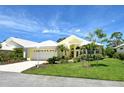 Inviting yellow single-Gathering home with white roof, lush lawn, and tropical landscaping at 340 Bermuda Ct # 5, Venice, FL 34293