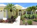 Beautiful yellow home exterior with tropical landscaping, stone walkway and double door entry at 340 Bermuda Ct # 5, Venice, FL 34293