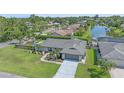 A high angle shows a landscaped home with a gray roof, lawn, and waterway behind the property at 4396 Pasadena Cir, Sarasota, FL 34233