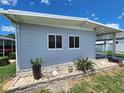 This single-story home boasts light-grey siding, white-trimmed windows and a charming landscaped accent at 5316 Chateau Ln, Bradenton, FL 34207