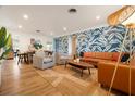 A stylish living room featuring modern furniture, a colorful wallpaper, and wood-look floors at 6180 42Nd N Ave, St Petersburg, FL 33709