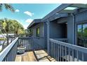 View of a blue condo from the wood balcony with view of the parking lot and palm trees at 7214 Cloister Dr # 7214, Sarasota, FL 34231
