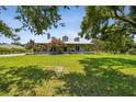 A cozy single-story home with a charming front porch, set against a blue sky and lush green lawn at 7264 Spencer Parrish Rd, Parrish, FL 34219