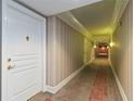 Hallway with neutral-toned striped wallpaper and ornate patterned carpet at 750 N Tamiami Trl # 1005, Sarasota, FL 34236