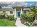 Close-up of a home's entry, highlighting the vibrant blue door and manicured landscaping at 813 Oak Pond Dr, Osprey, FL 34229