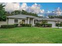 Inviting single-story home showcasing a lush lawn and a bright front entrance with decorative columns at 813 Oak Pond Dr, Osprey, FL 34229