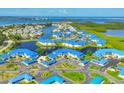 Aerial view of waterfront community with blue roofs, lush landscaping, and beautiful bay views at 840 Audubon Dr, Bradenton, FL 34209