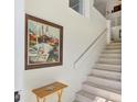 Bright staircase with decorative painting and painting of boats hanging on the wall at 840 Audubon Dr, Bradenton, FL 34209