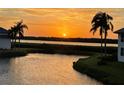 Beautiful sunset view from waterfront property with palm trees, a serene landscape, and tranquil waters at 840 Audubon Dr, Bradenton, FL 34209
